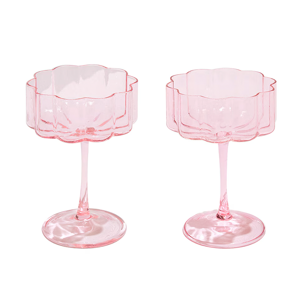 Two hand blown pink glass coup cocktail or dessert dishes on a white background