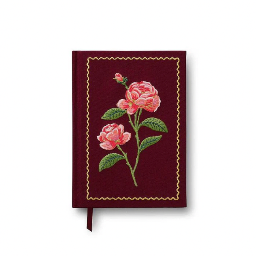 Red cloth notebook with  a rose floral design on a white background