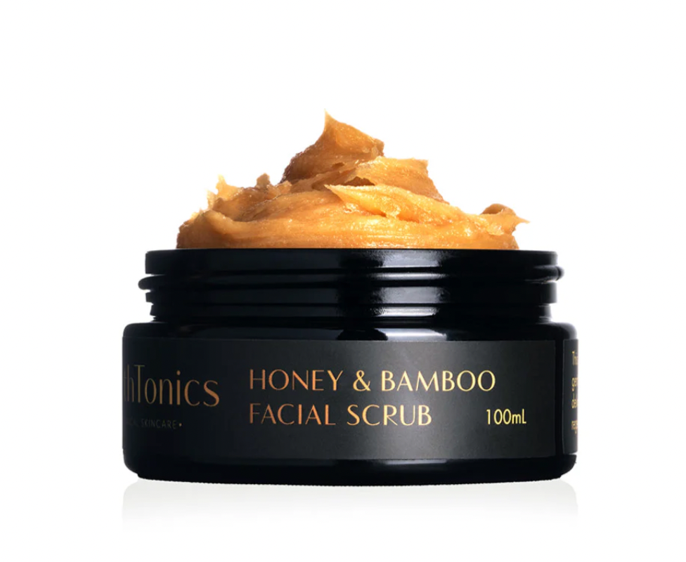 Black jar of Honey & Bamboo Facial Scrub with visible scrub on top against a white background