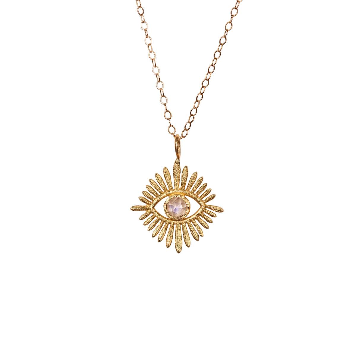 Gold necklace with an eye-shaped moonstone pendant on a beige background