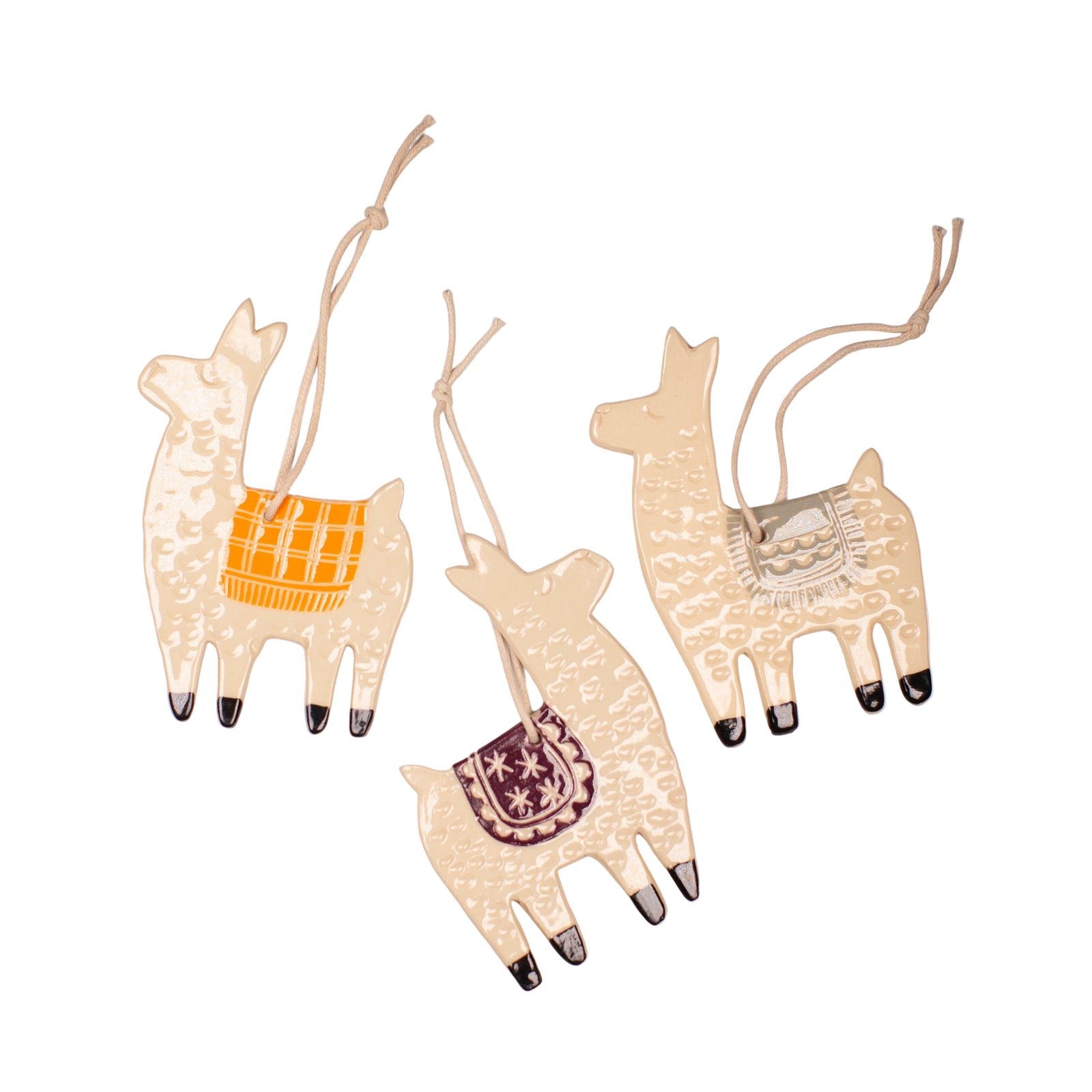 Three decorative ceramic llama ornaments with patterns on a light gray background