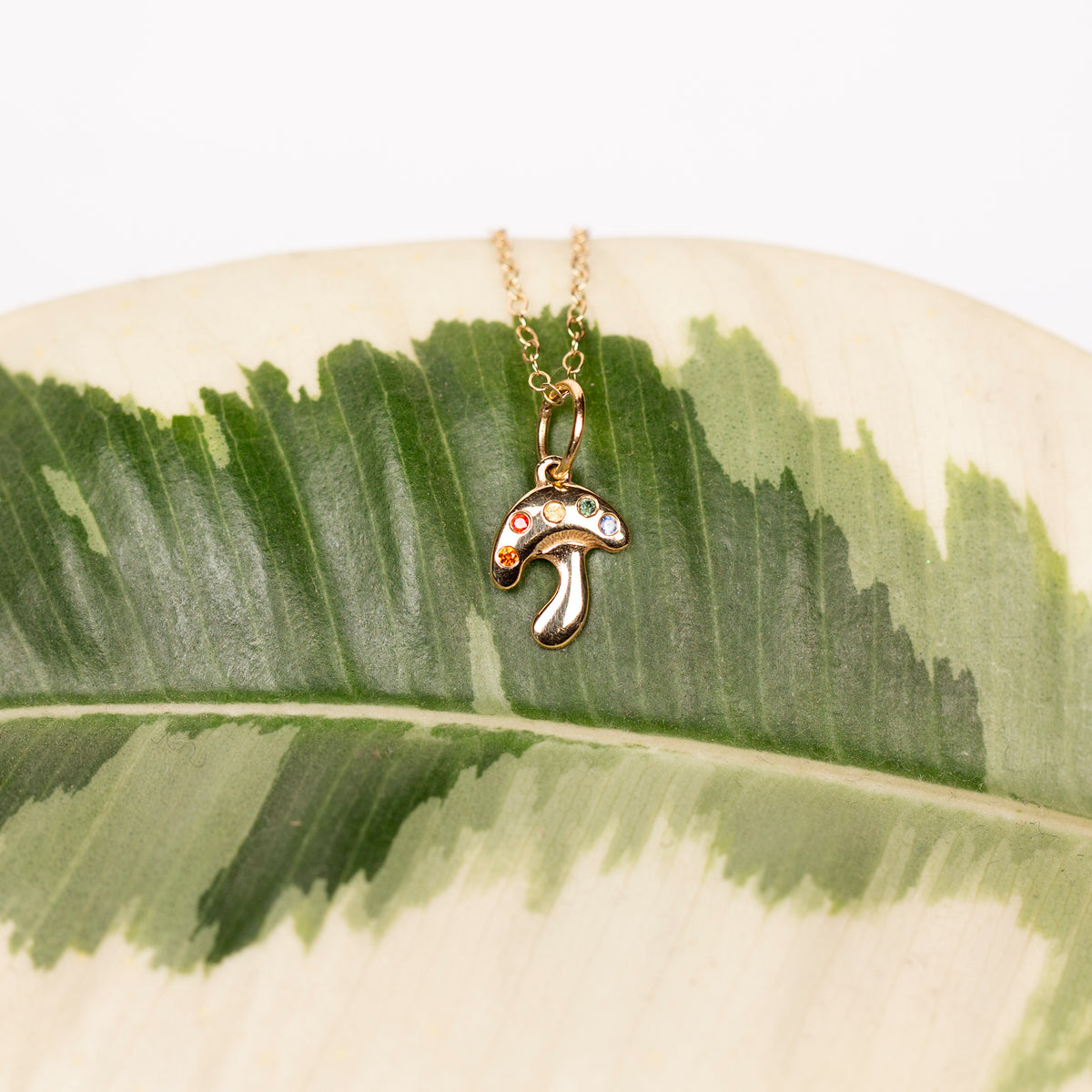Necklace with a mushroom pendant on a leaf background