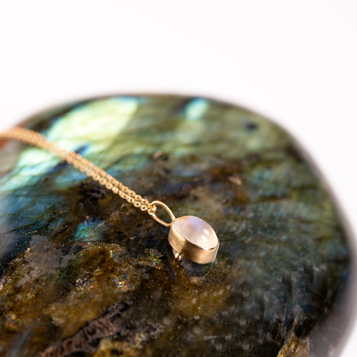 Gold necklace with a pendant on a labradorite stone